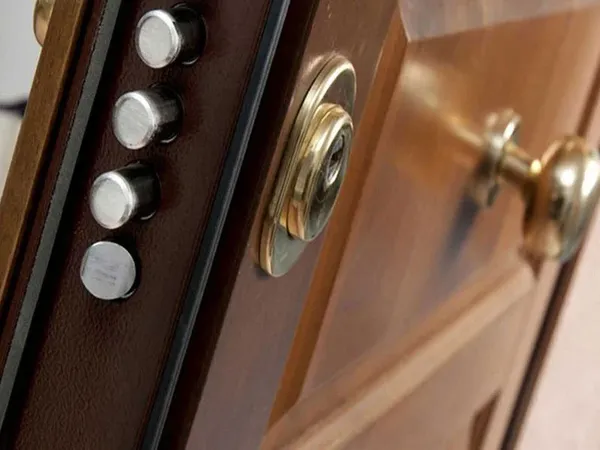 Catenacci e defender di una porta blindata rivestita in legno — Cotignola (RA)